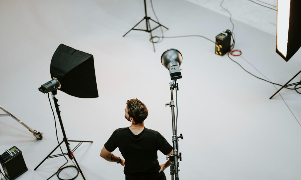 a man standing in a studio setup with studio lighting equipments