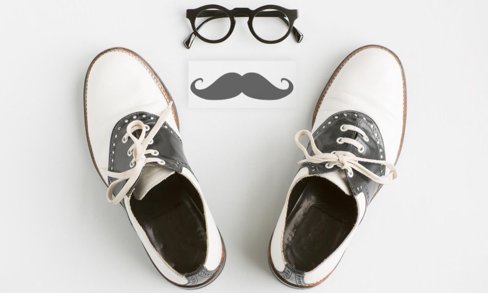 Close-up of men shoes with moustache and eyeglasses