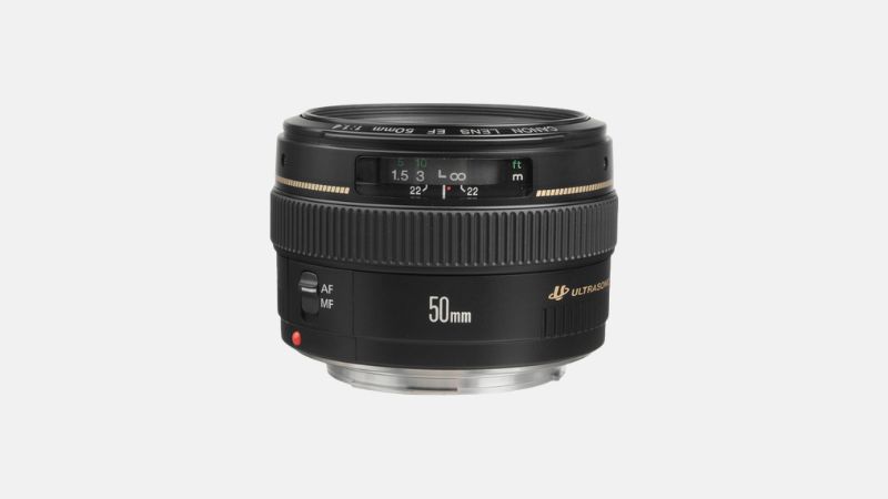 A black Canon EF 50mm f/1.4 USM prime lens is centered against a plain light gray background, viewed slightly from above