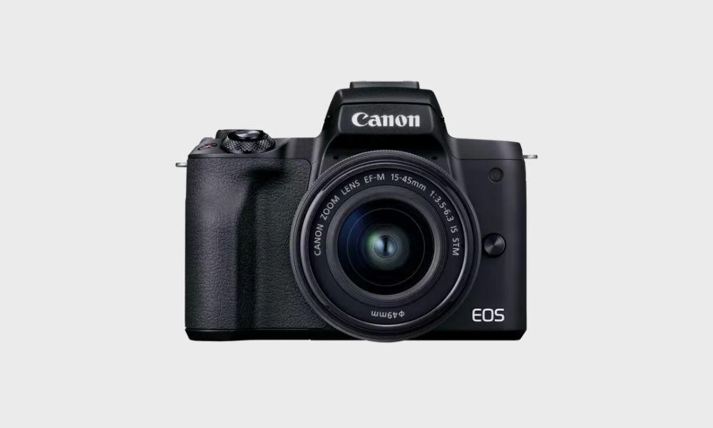 A black Canon EOS M50 Mark II mirrorless camera with an EF-M 15-45mm f/3.5-6.3 IS STM lens attached is displayed front-on against a plain light gray background