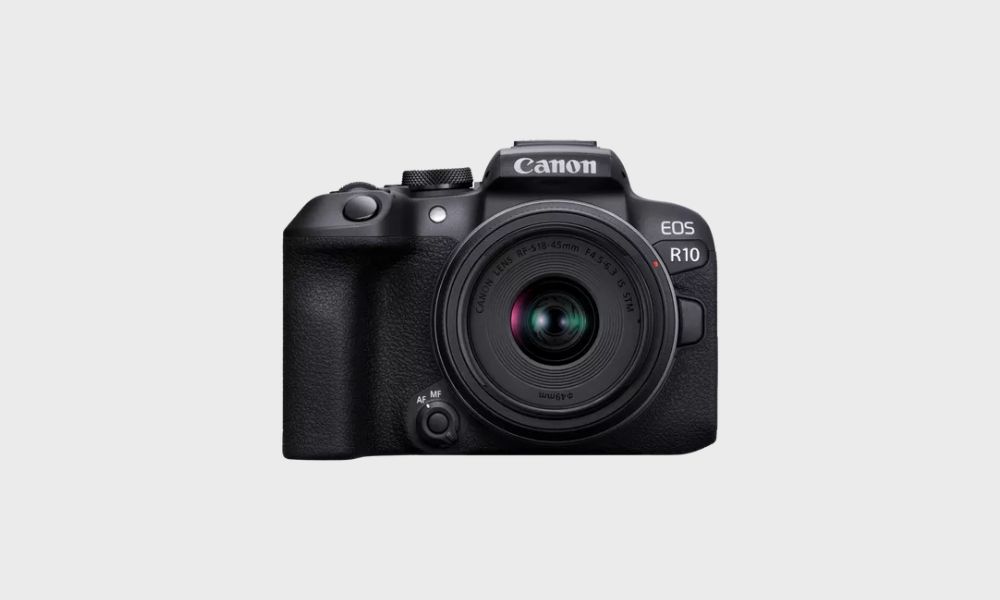 A black Canon EOS R10 mirrorless camera with an RF-S 18-45mm f/4.5-6.3 IS STM lens attached is displayed front-on against a plain light gray background