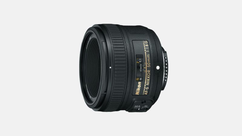 A black Nikon AF-S Nikkor 50mm f/1.8G lens is displayed at an angle against a plain light gray background