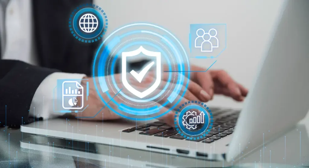 A close-up of a person's hands typing on a laptop keyboard, with various digital security and business icons floating above, including a shield with a checkmark, a globe, people, a document, and a gear