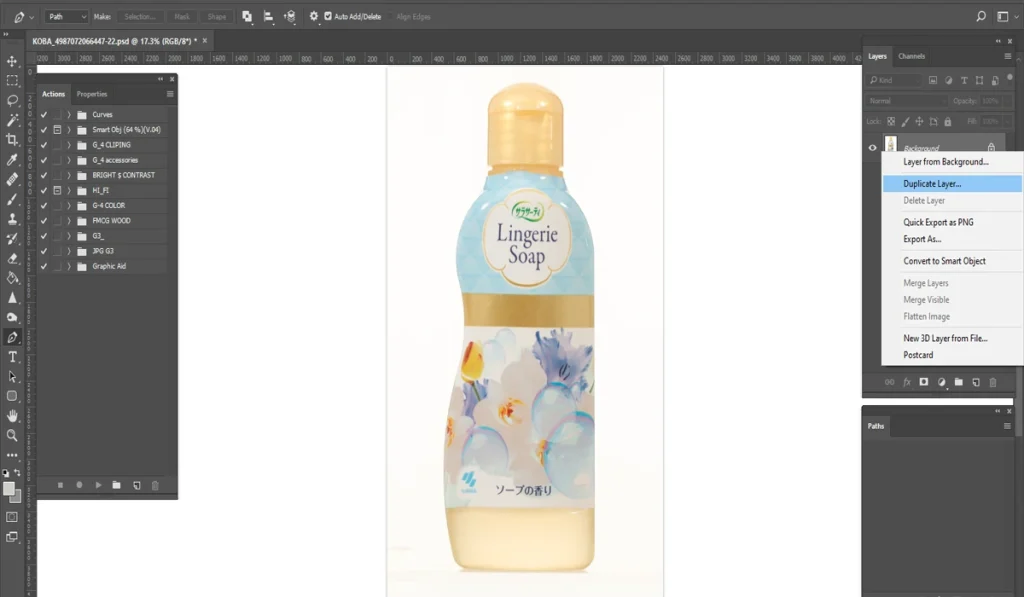 A screenshot of Adobe Photoshop shows a bottle of "Lingerie Soap" with a floral design on a white background, with the "Duplicate Layer" option highlighted in the Layers panel on the right