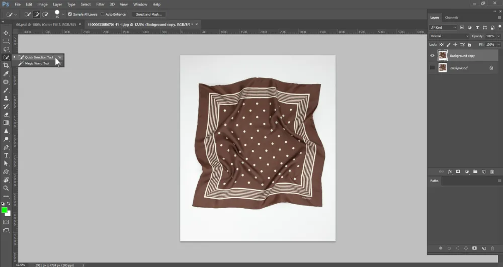 Screenshot of Adobe Photoshop showing a brown polka-dotted scarf on a white background. The Quick Selection Tool is being selected from the toolbar on the left side, with the tool options dropdown expanded to also reveal the Magic Wand Tool. The Layers panel on the right shows two layers: "Background copy" and "Background."
