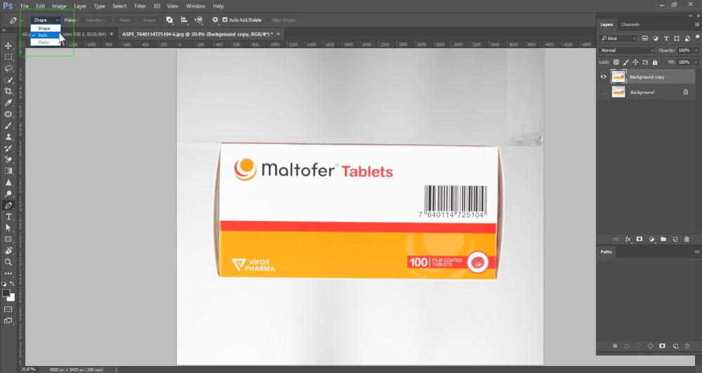 A Photoshop screenshot displays a white and orange box of "Maltofer Tablets" on a white background. A dropdown menu is open from the "Pen Tool" options bar at the top, showing "Shape," "Path," and "Pixels," with "Path" highlighted. The layers panel on the right shows "Background copy" and "Background" layers