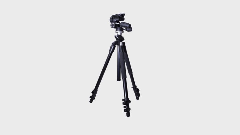 A black camera tripod with its legs extended and a camera head mounted on top, standing against a plain white background