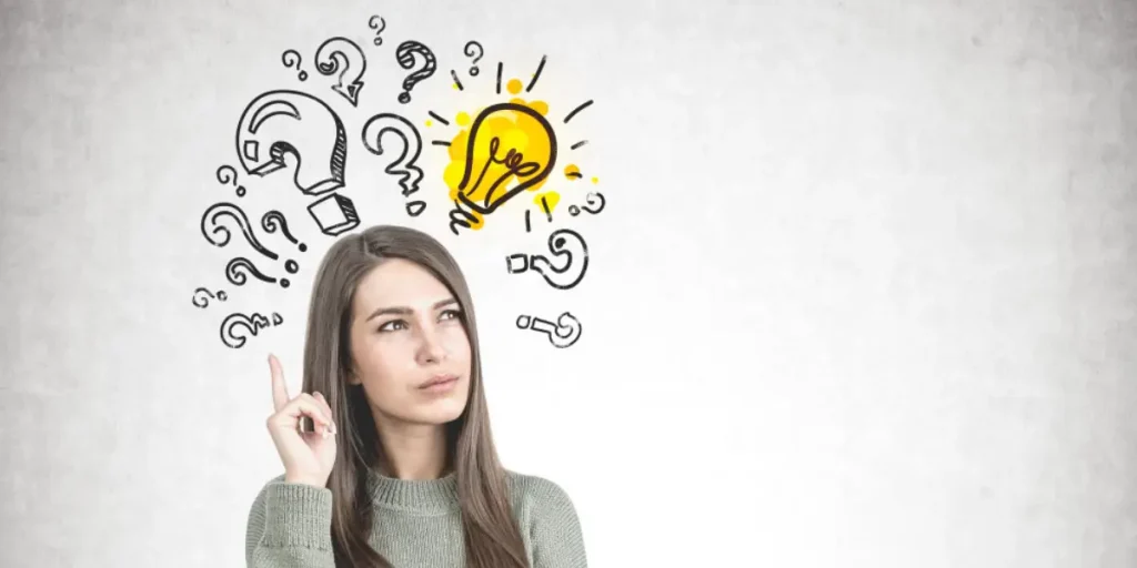 A young woman with long, dark hair wears a grey sweater and looks upwards with a thoughtful expression, her index finger touching her temple, surrounded by hand-drawn question marks and a glowing lightbulb illustration on a light grey background