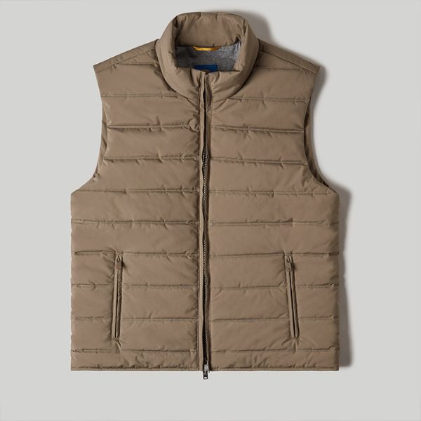 A khaki-colored puffer vest with a high collar and a front zipper, laid flat and smoothed on a plain grey background