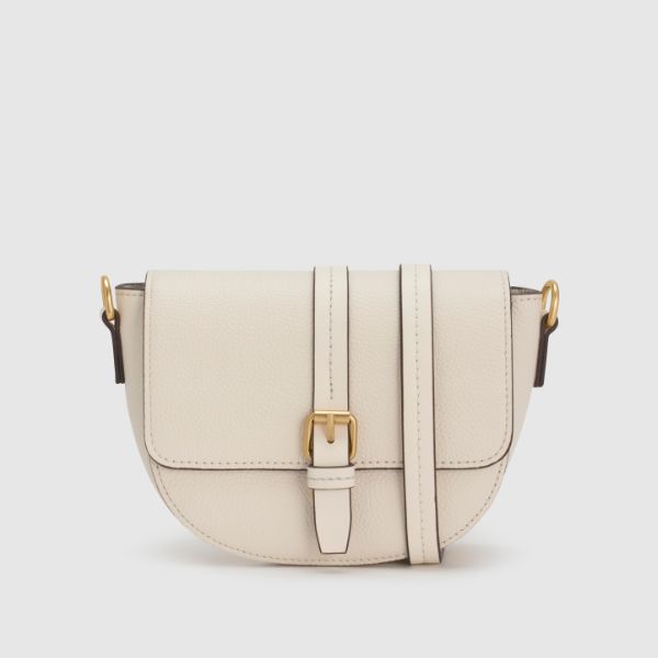 An off-white or cream-colored leather saddle bag with a gold-colored buckle and a thin strap, displayed on a plain grey background