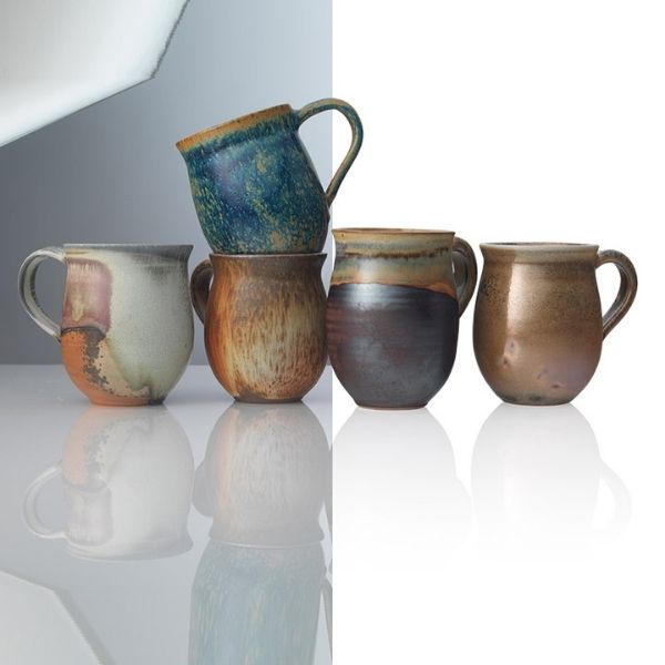 A "before and after" image of five ceramic mugs. The "Before" shows them on a reflective surface with a grey and white background, while the "After" displays the identical setup with a clean, pure white background, showcasing product photo editing.