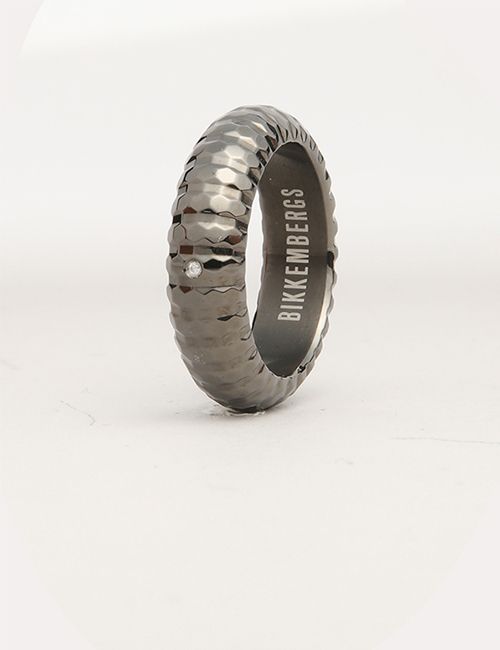 A dark, textured ring with a small diamond and "BIKKEMBERGS" engraved on the inside, set on a plain white surface.