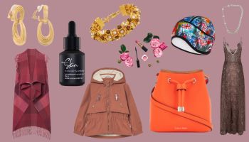 A diverse collection of fashion accessories and beauty products on a pink background, including gold earrings, a black dropper bottle, a gold jeweled bracelet, a multi-colored helmet, lipstick and makeup brushes with pink roses, an orange bucket bag, and a brown patterned dress