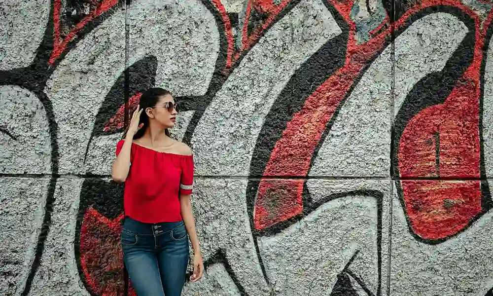Women pose with graffiti wall